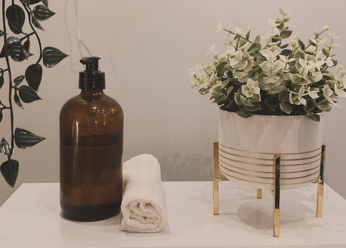 Relaxing setup at HB Holistic Massage, Belfast, Northern Ireland, GB with plant, towel, and amber bottle.