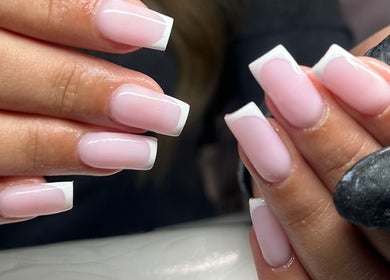 Classic French manicure at GLOW By Mads, Abbots Langley, England, GB. Perfectly polished nails in soft pink and white.