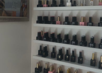 Nail polish display at 𝐆𝐋𝐎𝐖 By Mads in Abbots Langley, England, showcases vibrant colors and brands.