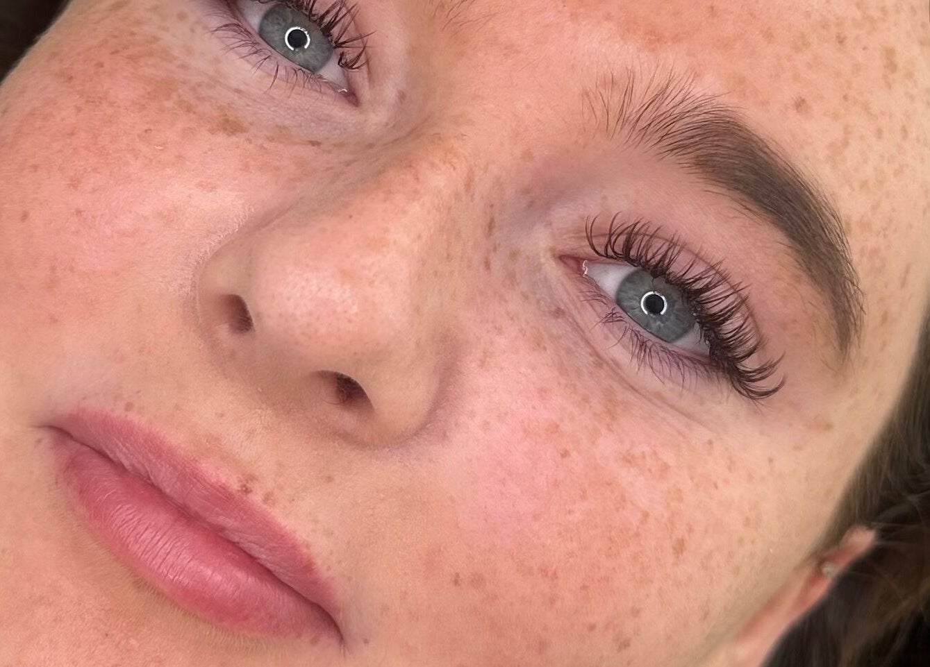 Close-up of radiant skin showcasing lash treatment at Glow by Mads in Abbots Langley, England, GB.