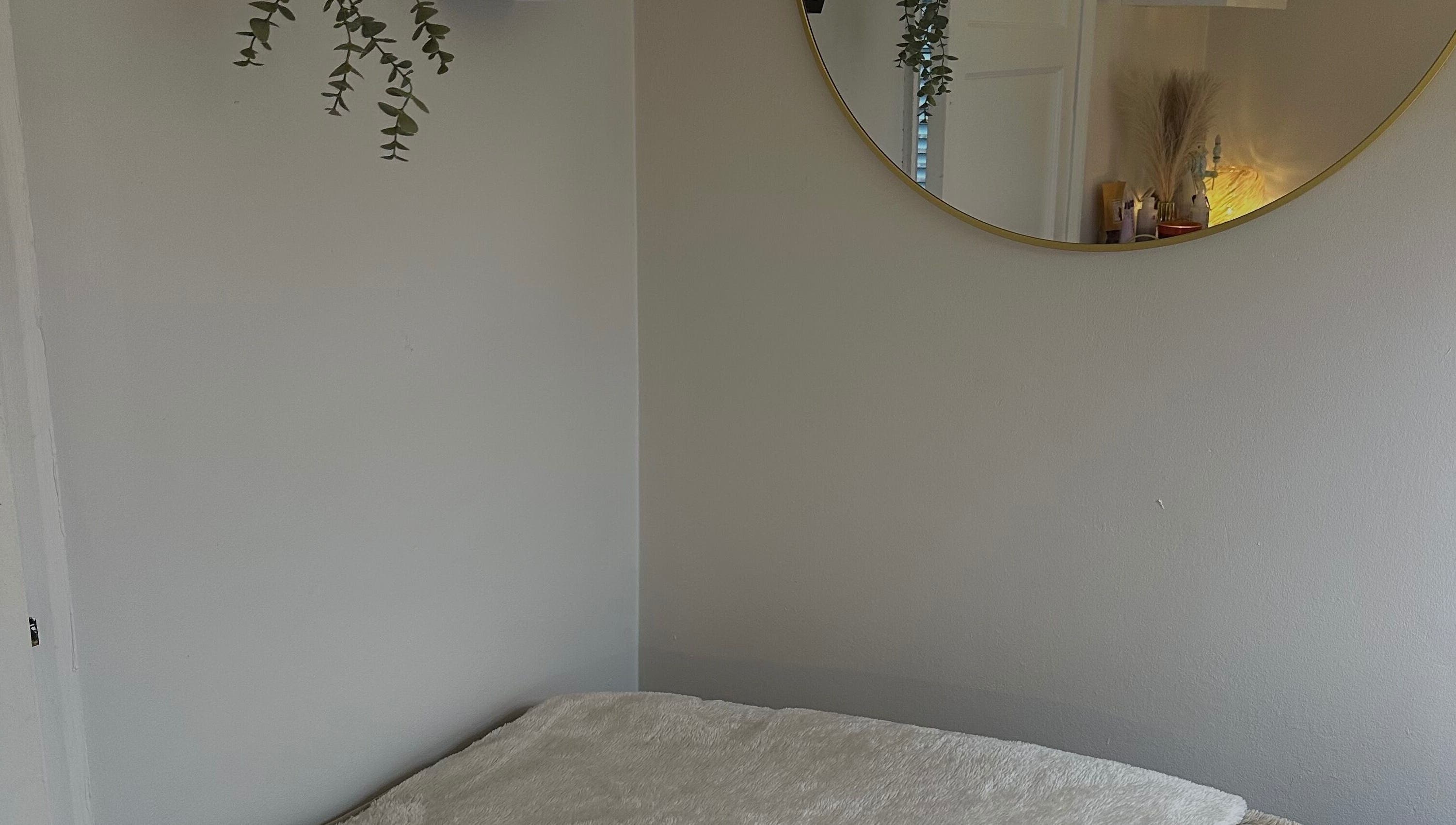 Relaxing treatment room with mirror at Glow by Mads Clinic, Abbots Langley, England, GB.