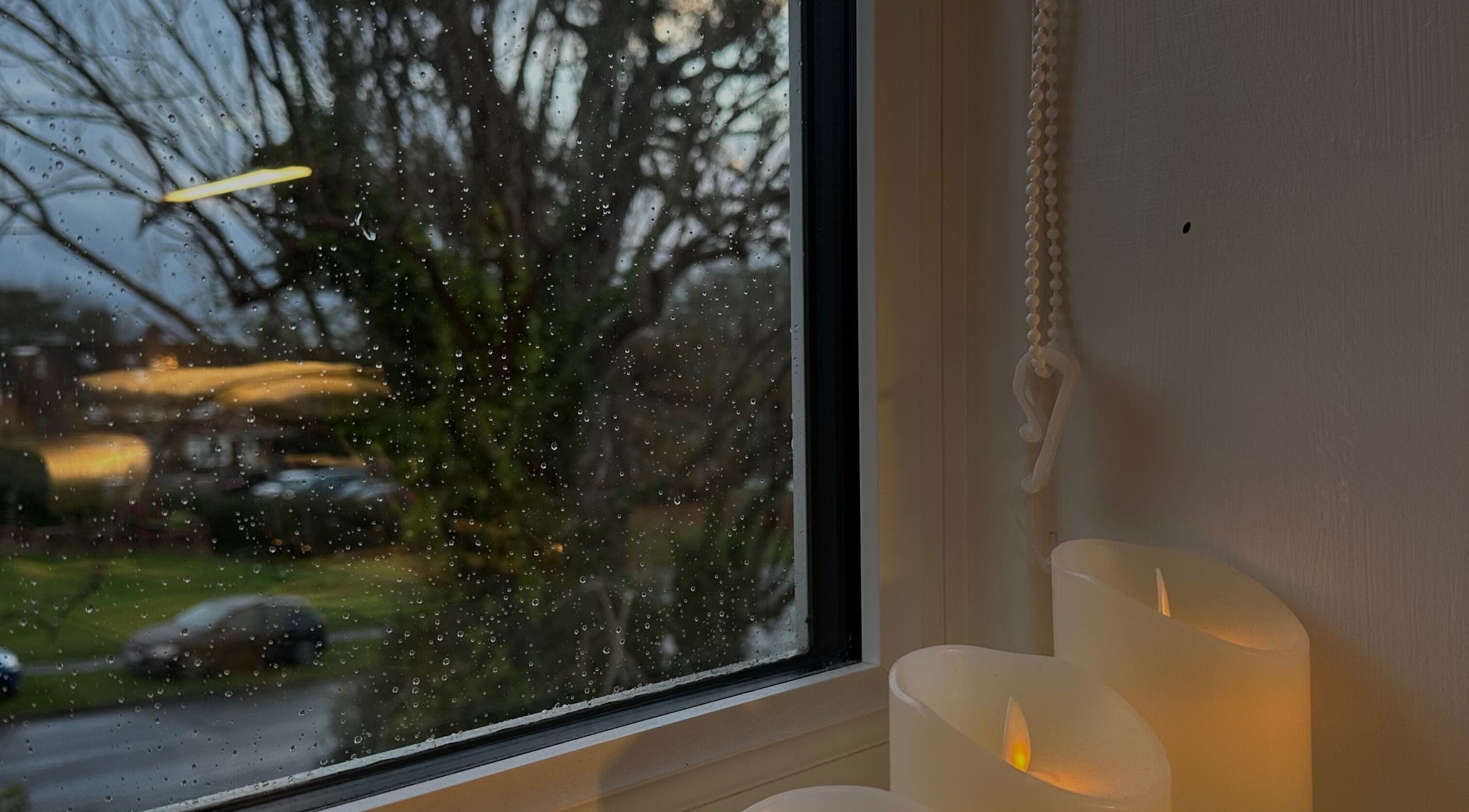 Glowing candles by a rainy window at Glow by Mads Clinic, Abbots Langley, England, GB.