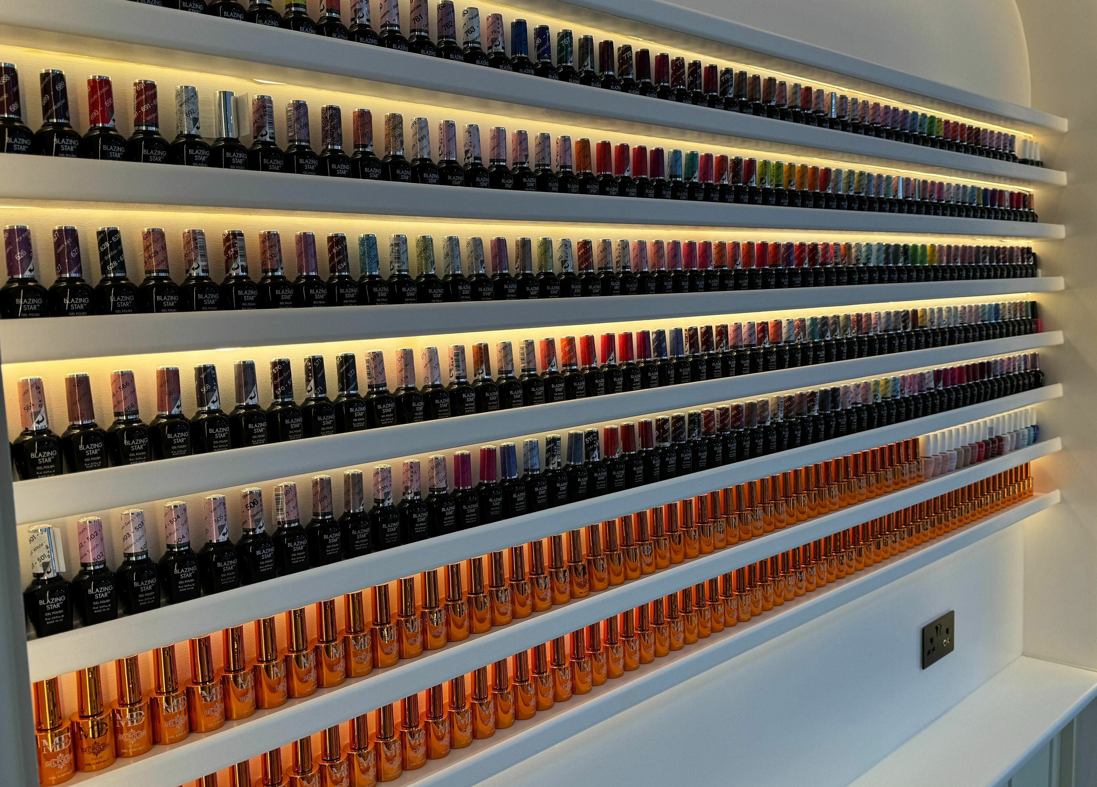 Colorful nail polish display at Mau Beauty, London, England, GB. Shelves of vibrant hues enhance the venue's appeal.