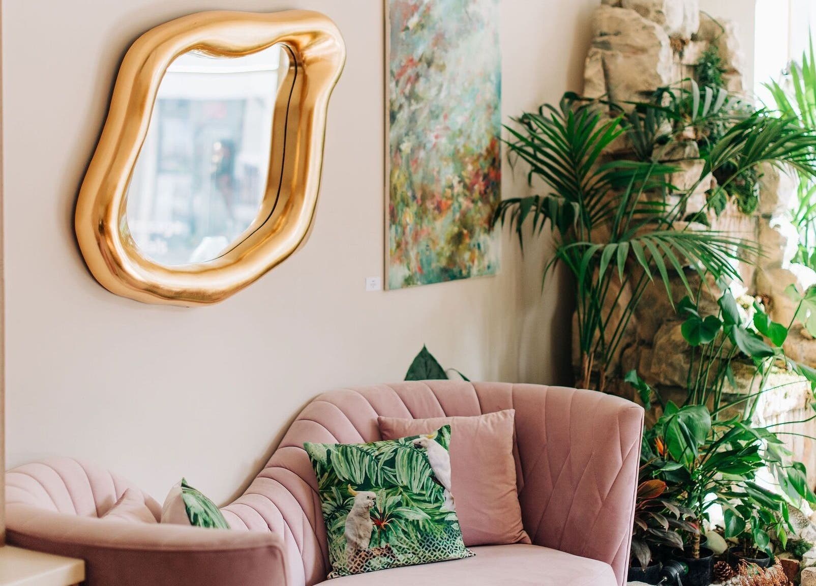 Luxurious pink seating and lush plants at Bayou Spa, London, England, GB, exude tranquility and elegance.