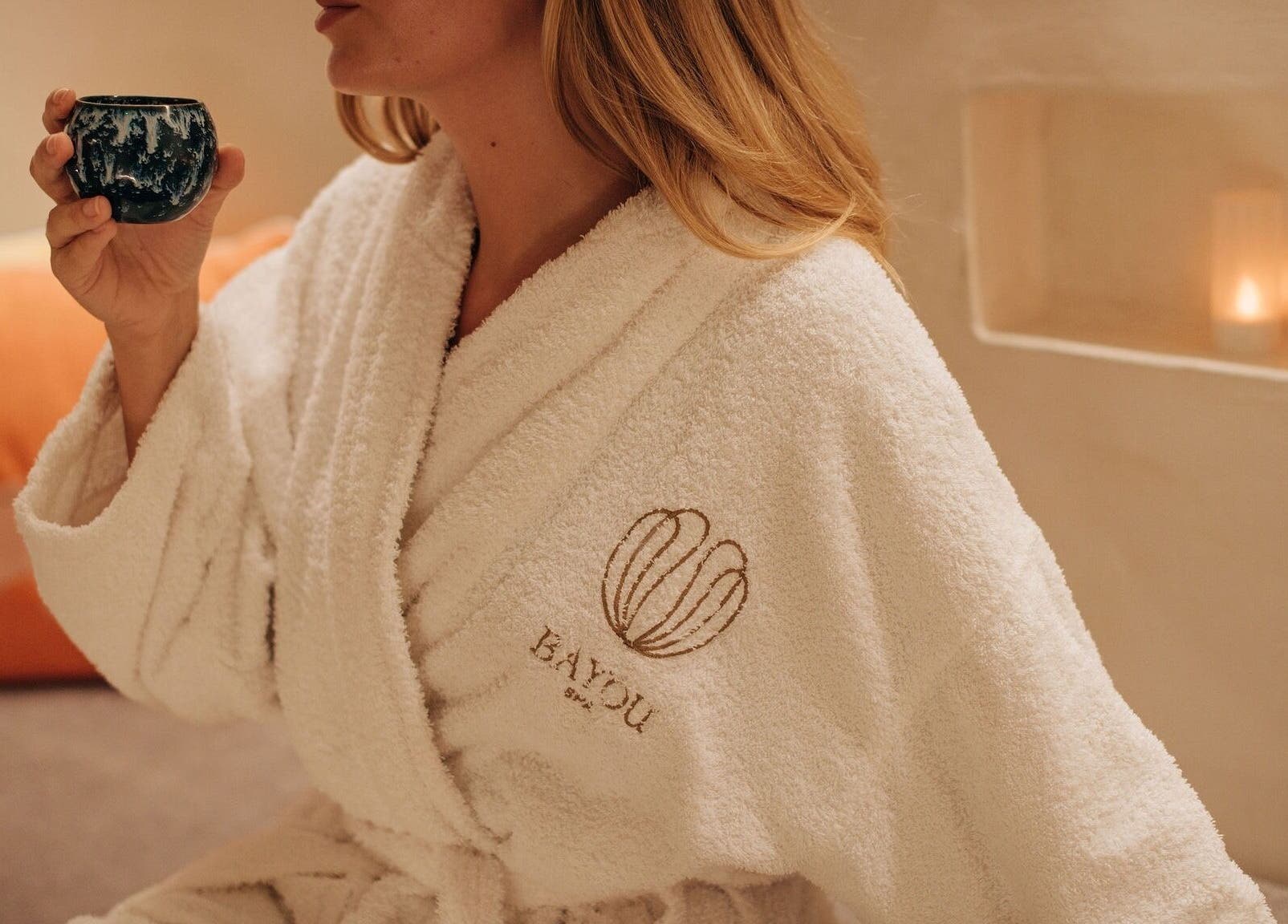 Relaxing moment at Bayou Spa, London, England, with guest in a robe enjoying a warm drink.