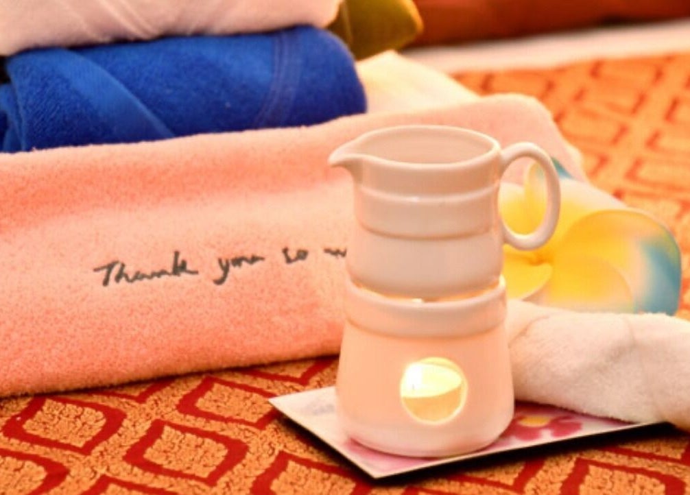 Relaxing spa setup with towels and candle at BaanMai Thai Massage and Spa, Tokyo, Minato-Ku, JP.