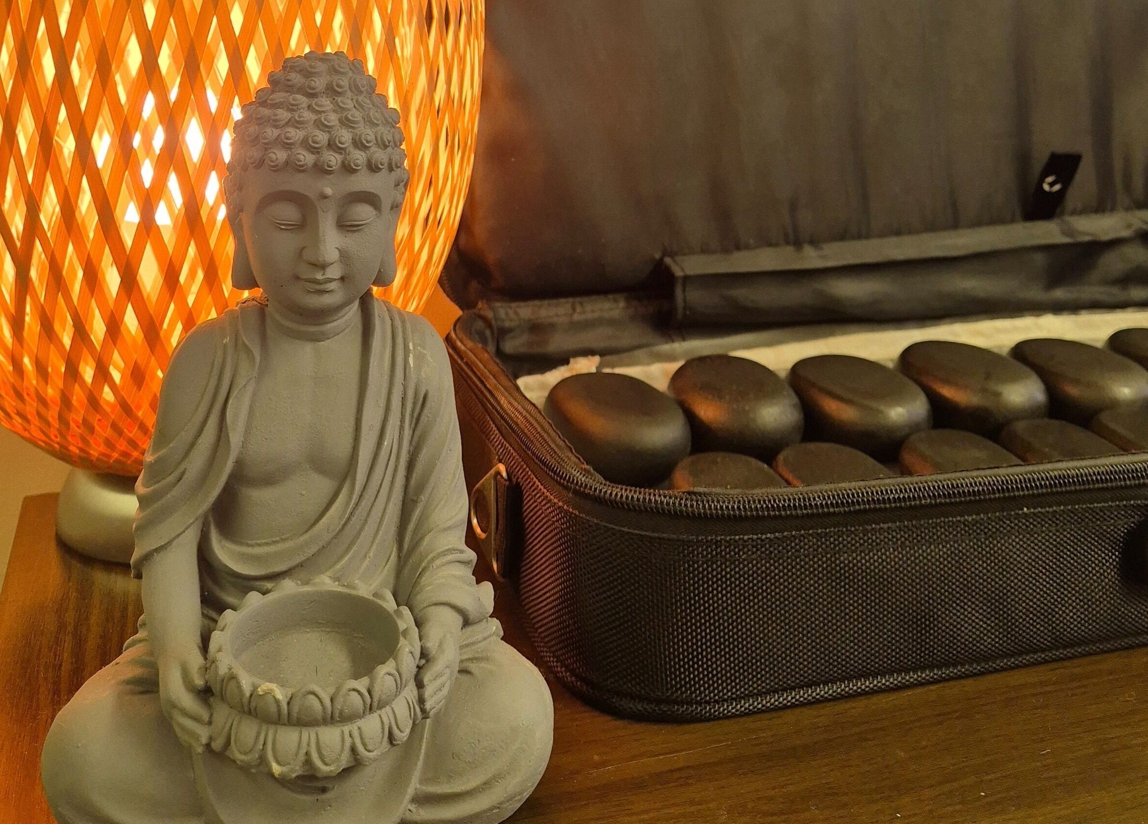 Calming Buddha statue with massage stones at Mandi O'Neill Holistics, Goole, England, GB.