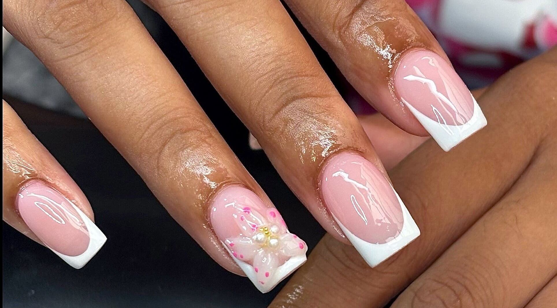 Elegant French manicure with flower detail at Nails by Kyra M, Scunthorpe, England, GB.