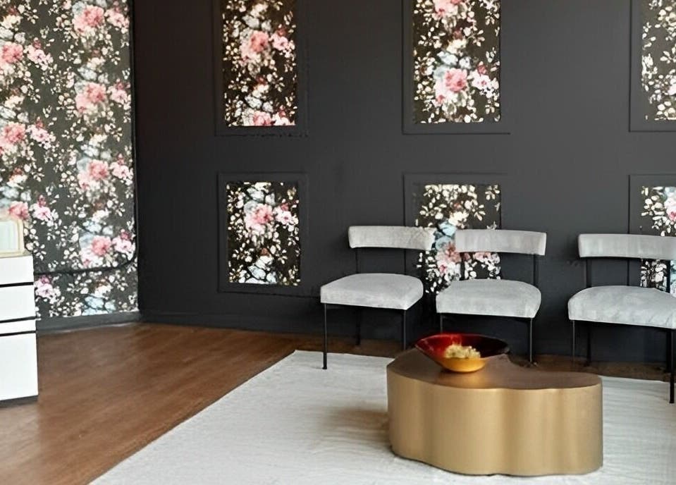 Stylish floral lounge area at Lash Culture, Calgary, Alberta, CA with chic chairs and gold table.