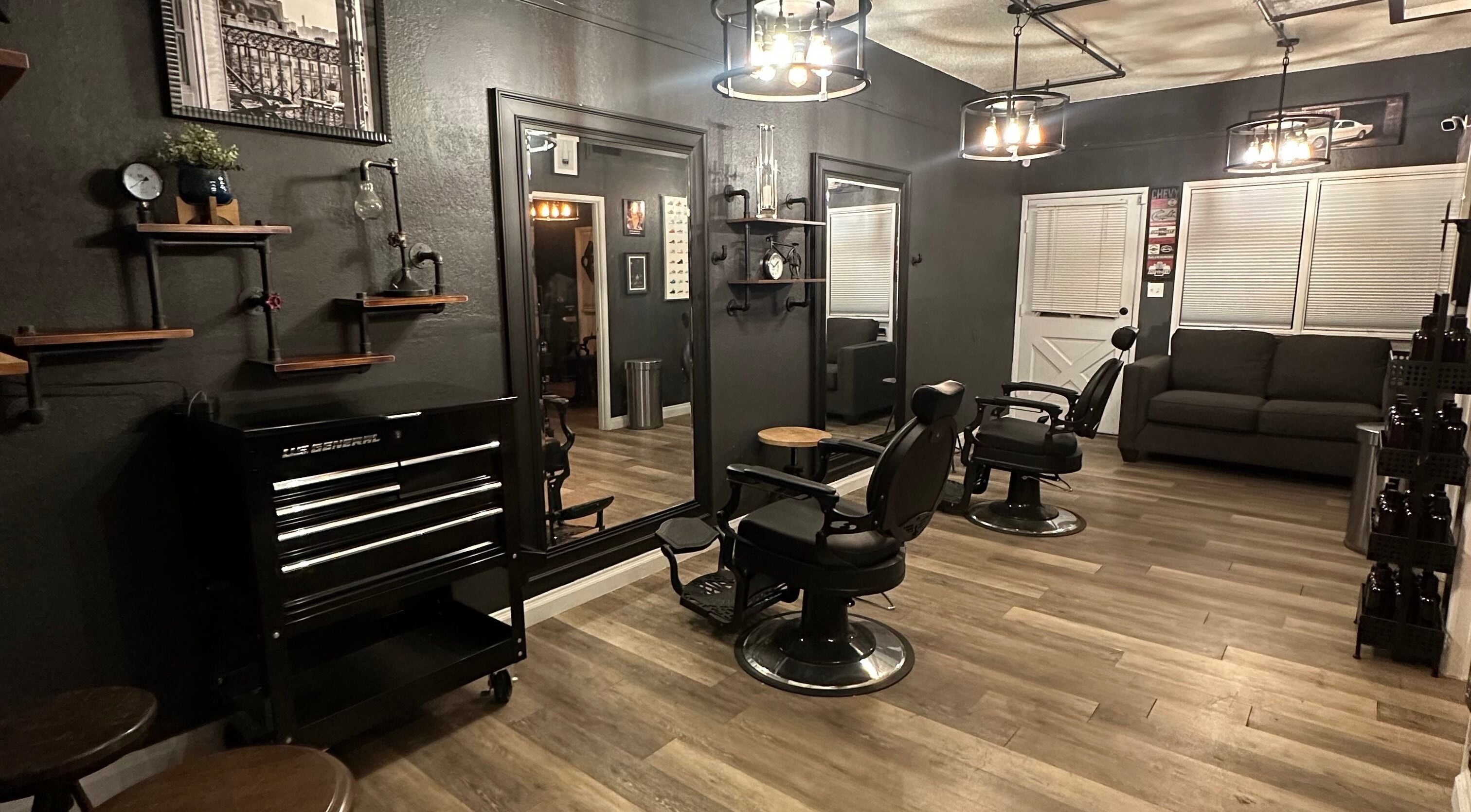 Elegant interior of Above All Barbershop in Fresno, California, US, featuring black chairs and modern lighting.