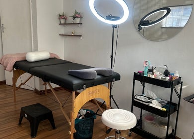 Glossy Aesthetics Studio's tranquil treatment room in Knysna, Western Cape, ZA, featuring a massage table and beauty tools.