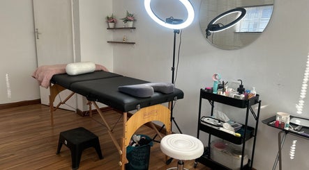 Glossy Aesthetics Studio's tranquil treatment room in Knysna, Western Cape, ZA, featuring a massage table and beauty tools.