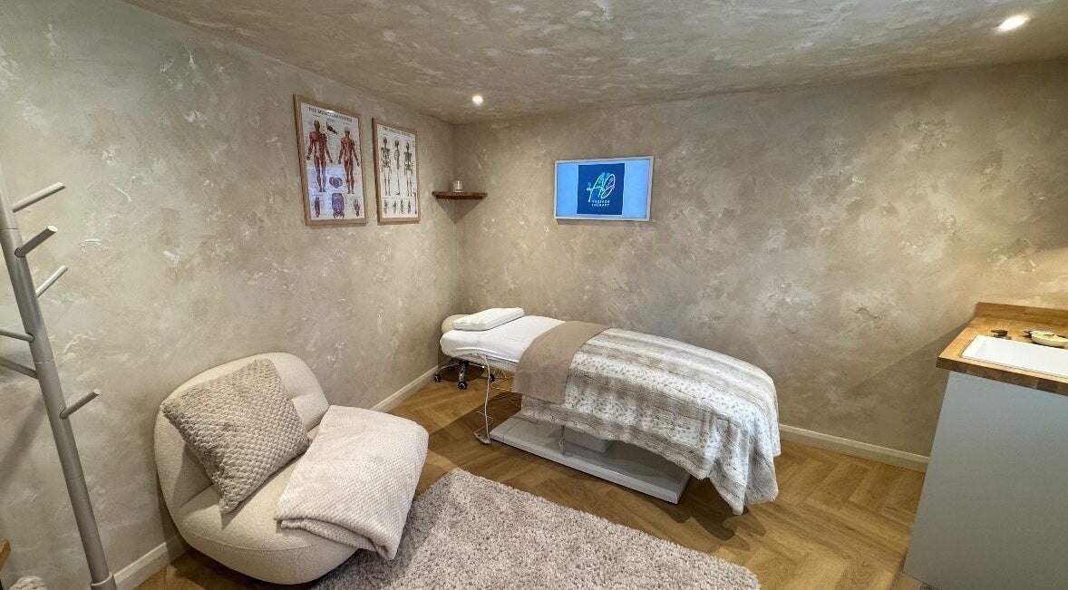 Tranquil massage room at AD Massage Therapy, Stratford-upon-Avon, England, GB, featuring a cozy chair and therapy bed.