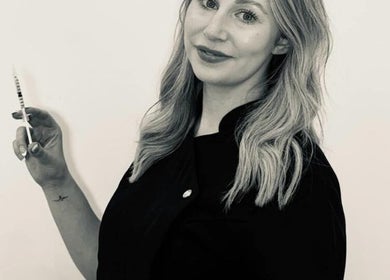 Professional at KLH Nurse Led Aesthetics in Morley, England, holding a syringe for aesthetic treatment.