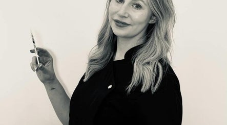 Professional at KLH Nurse Led Aesthetics in Morley, England, holding a syringe for aesthetic treatment.