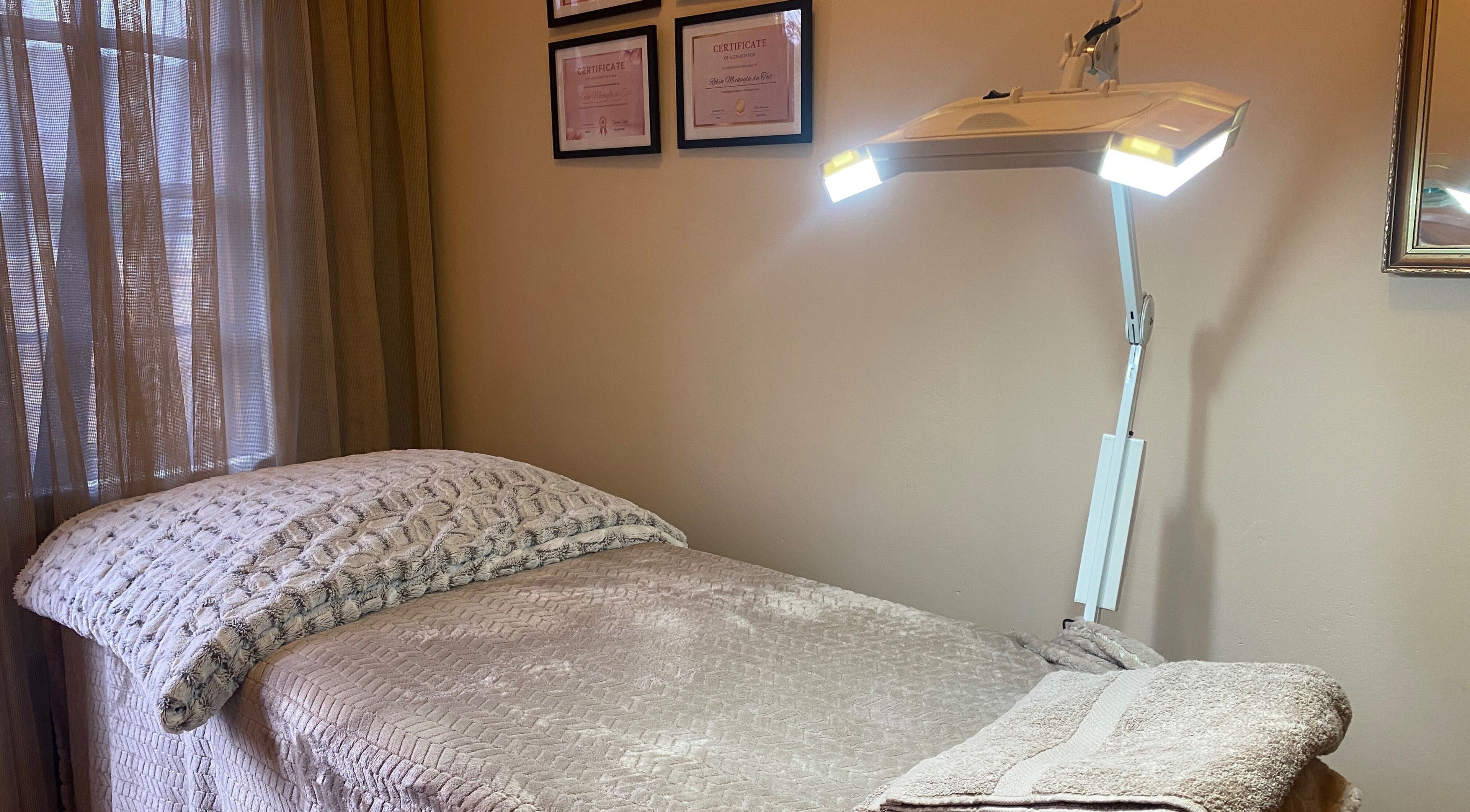 Calm treatment room at Feather Aesthetics, Bloemfontein, Free State, ZA featuring a cozy bed and soft lighting.