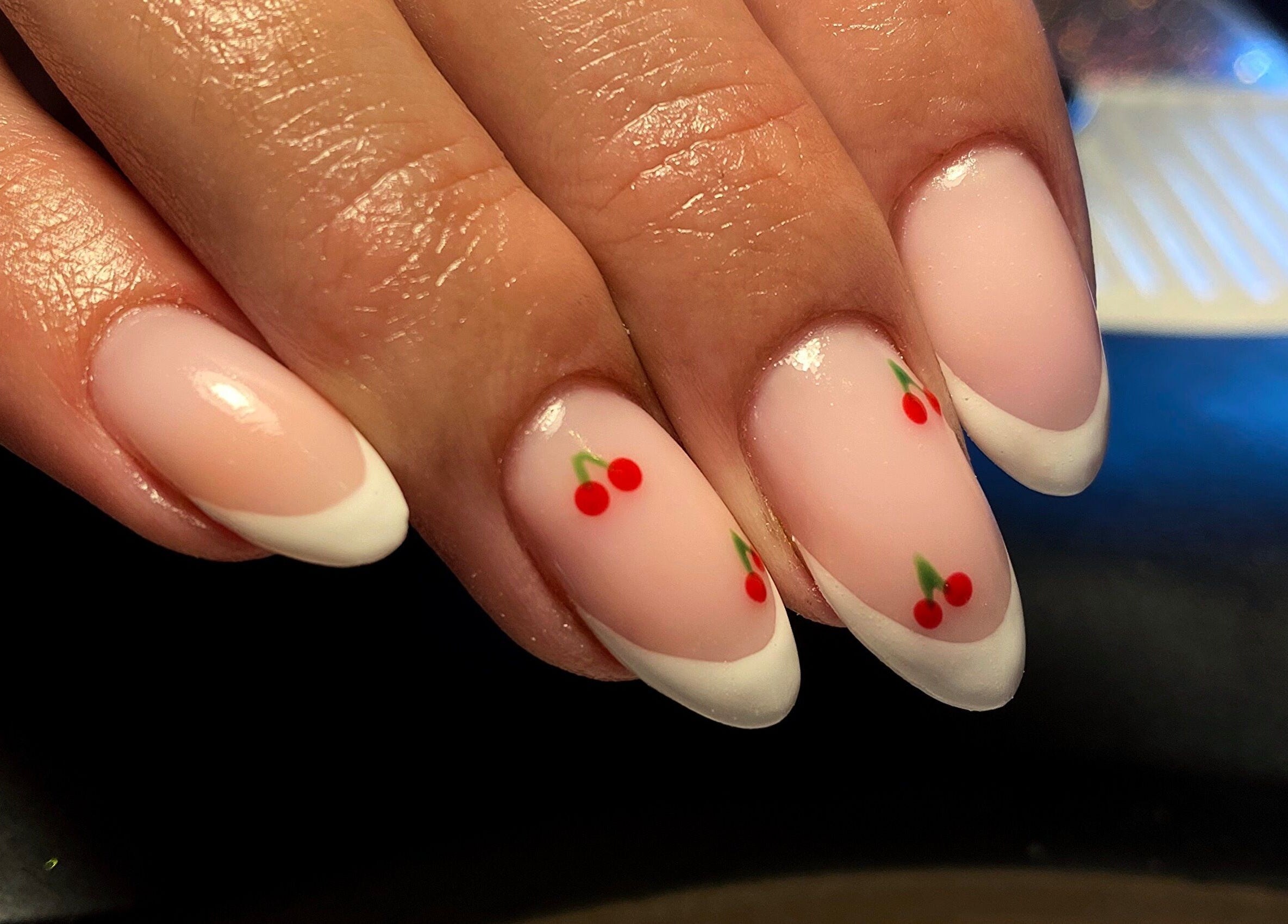 Cherry-themed nail art at Feather Aesthetics, Bloemfontein, Free State, ZA. Elegant white tips with cherry design.
