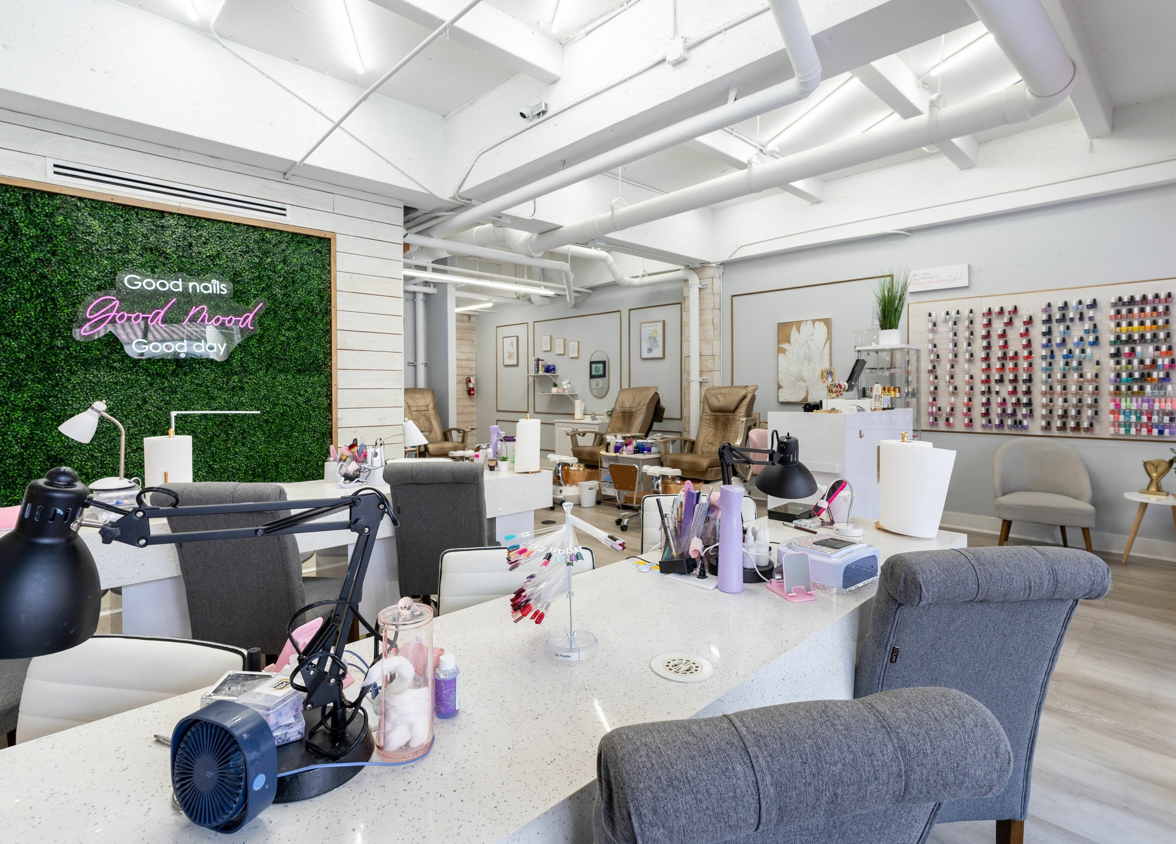 Modern interior of Nail Nova Salon & Spa in Miami Lakes, Florida, showcasing manicure stations and vibrant nail polish wall.