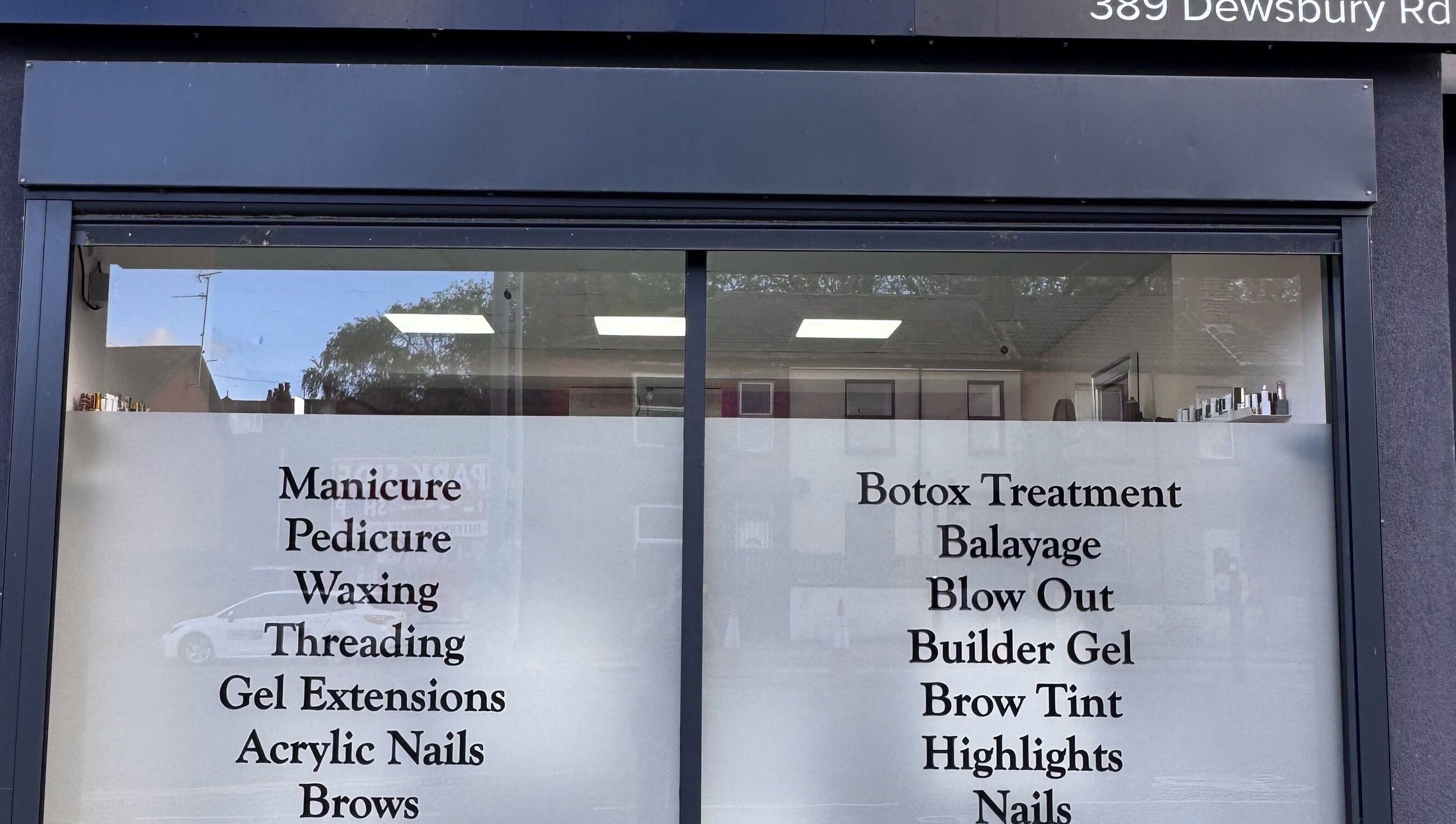 Service menu on window of Glam Aura Studio, Leeds, England, GB offering manicures to botox treatments.