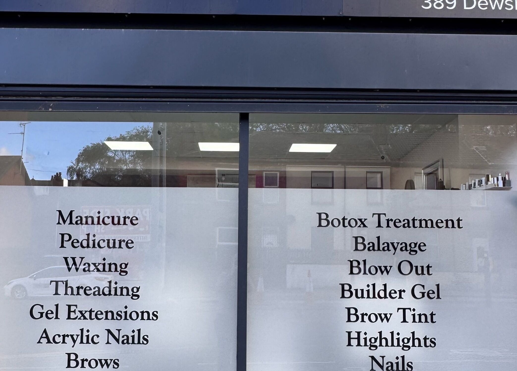 Service menu on window of Glam Aura Studio, Leeds, England, GB offering manicures to botox treatments.