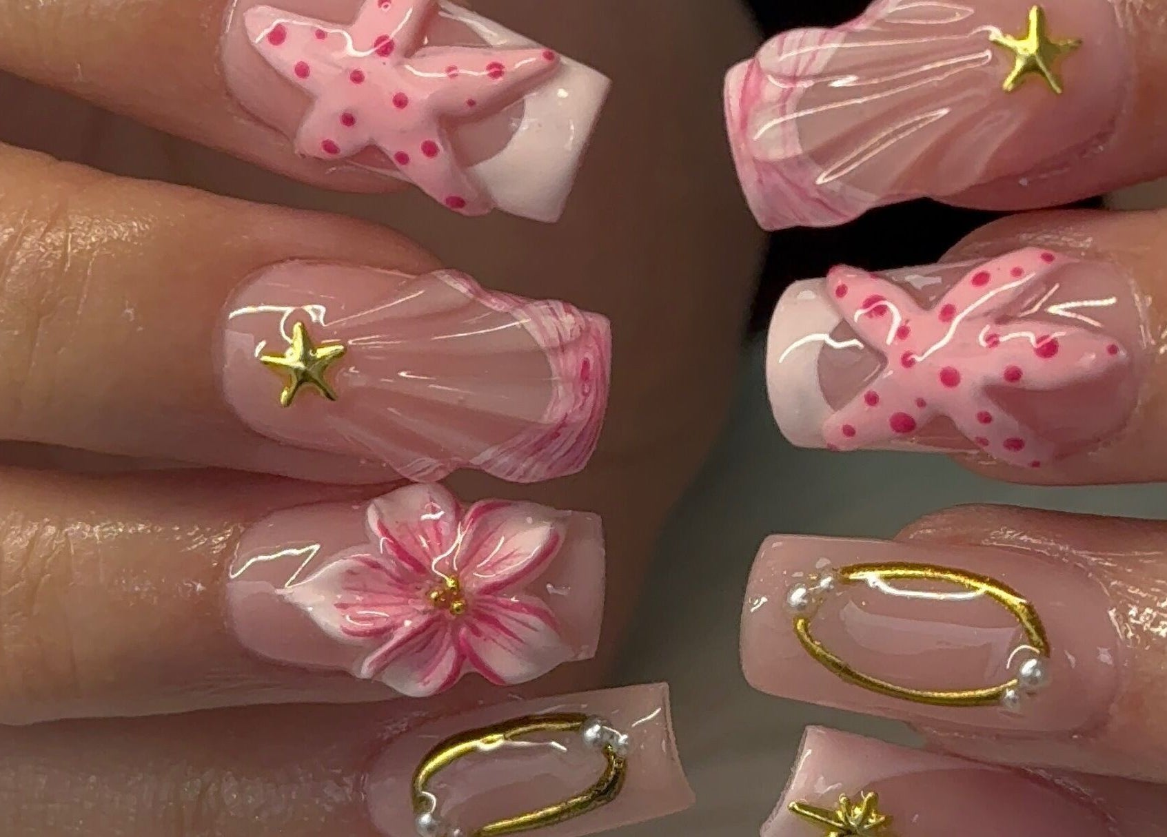 Intricate ocean-themed nail art at Glam Aura Studio in Leeds, England, GB featuring pink and gold starfish designs.