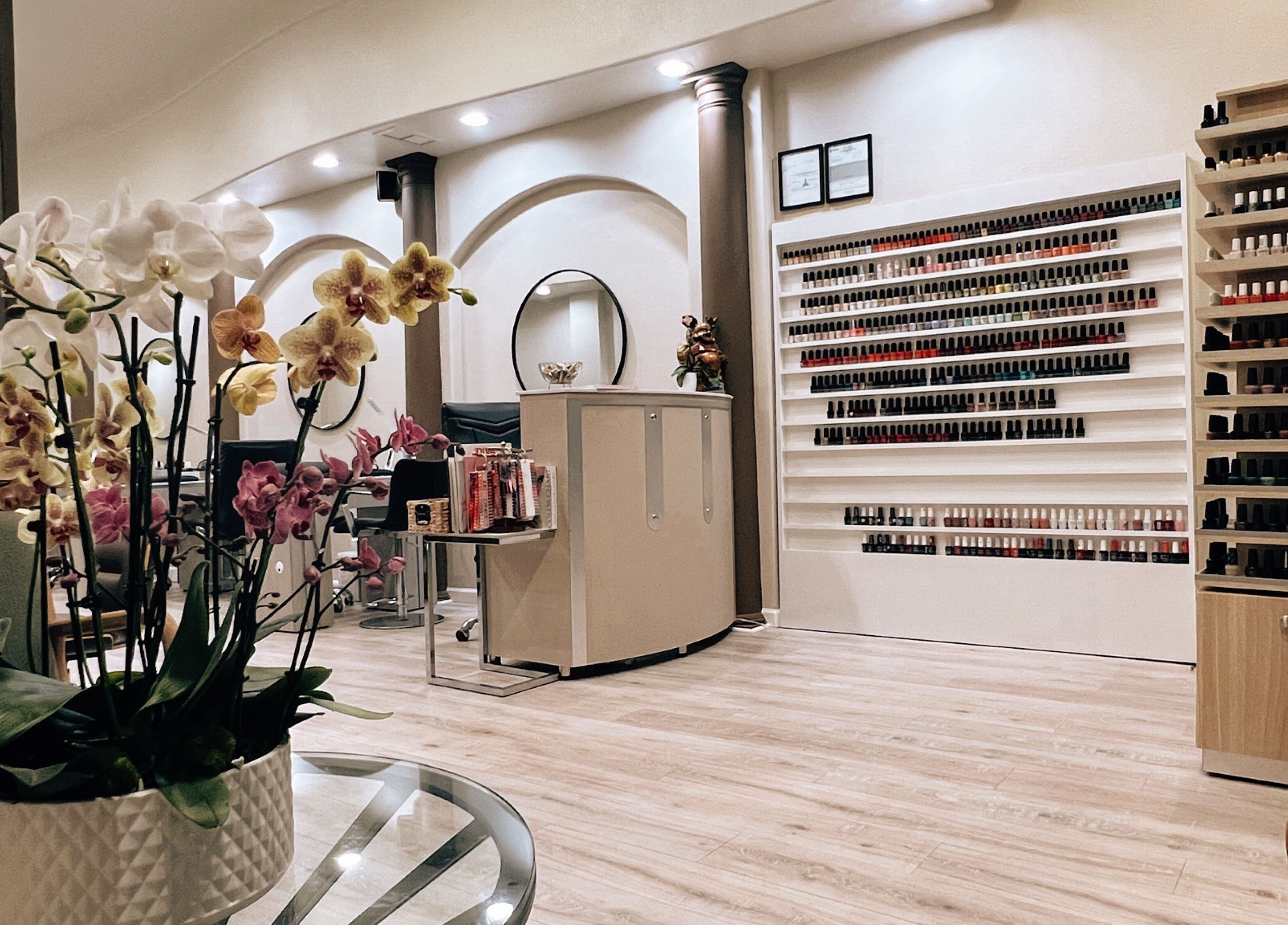 Peaceful interior of Nirvana Nails Studio, Studio City, California, US with orchids and nail polish wall.