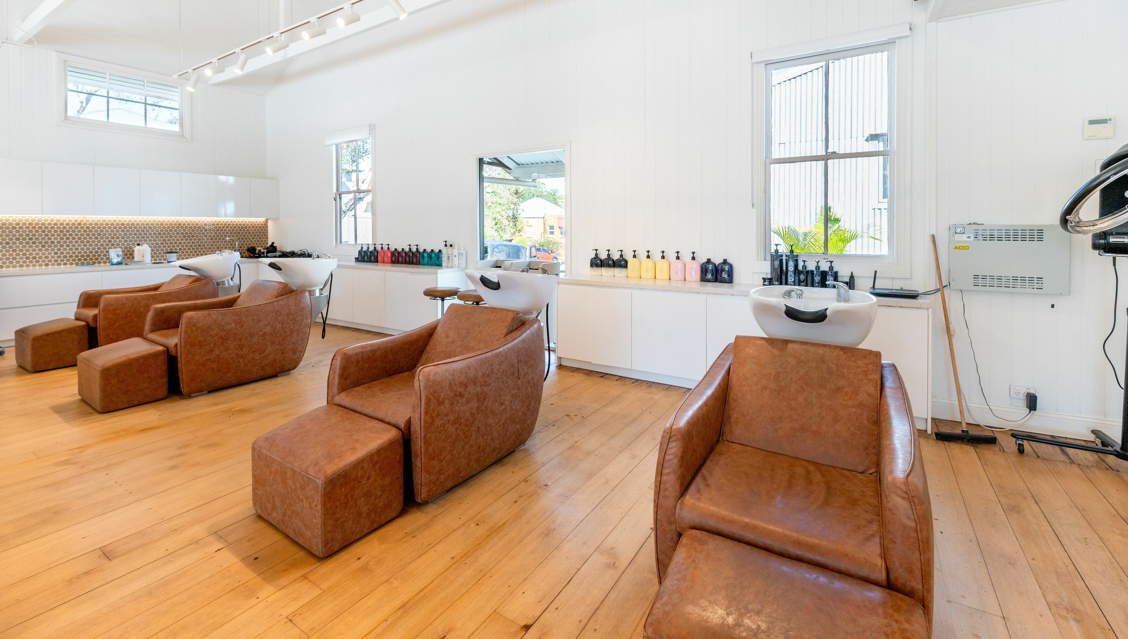Cozy washing area at The Mane Society, Kelvin Grove, Queensland, AU featuring modern chairs and stylish lighting.