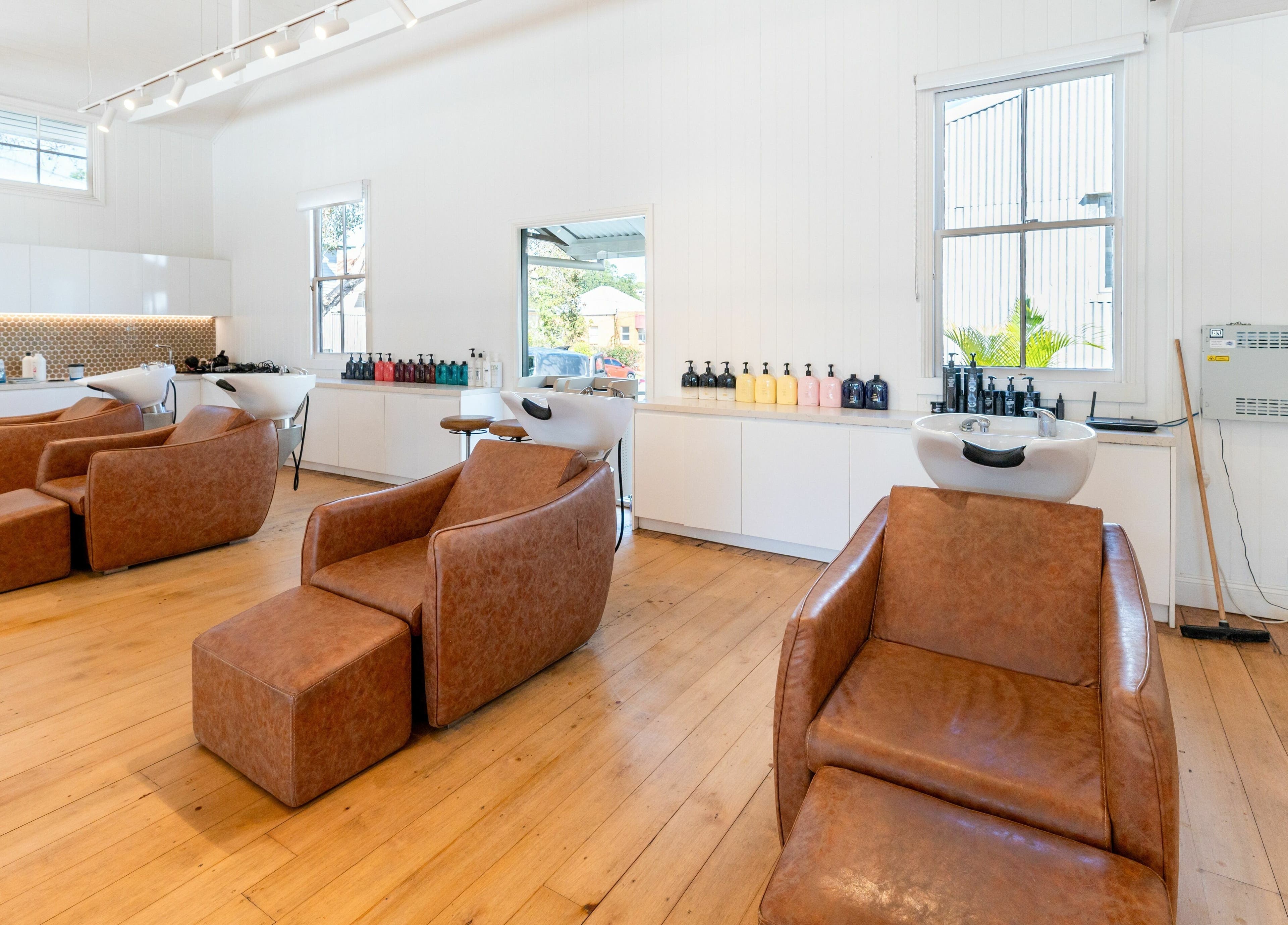 Cozy washing area at The Mane Society, Kelvin Grove, Queensland, AU featuring modern chairs and stylish lighting.