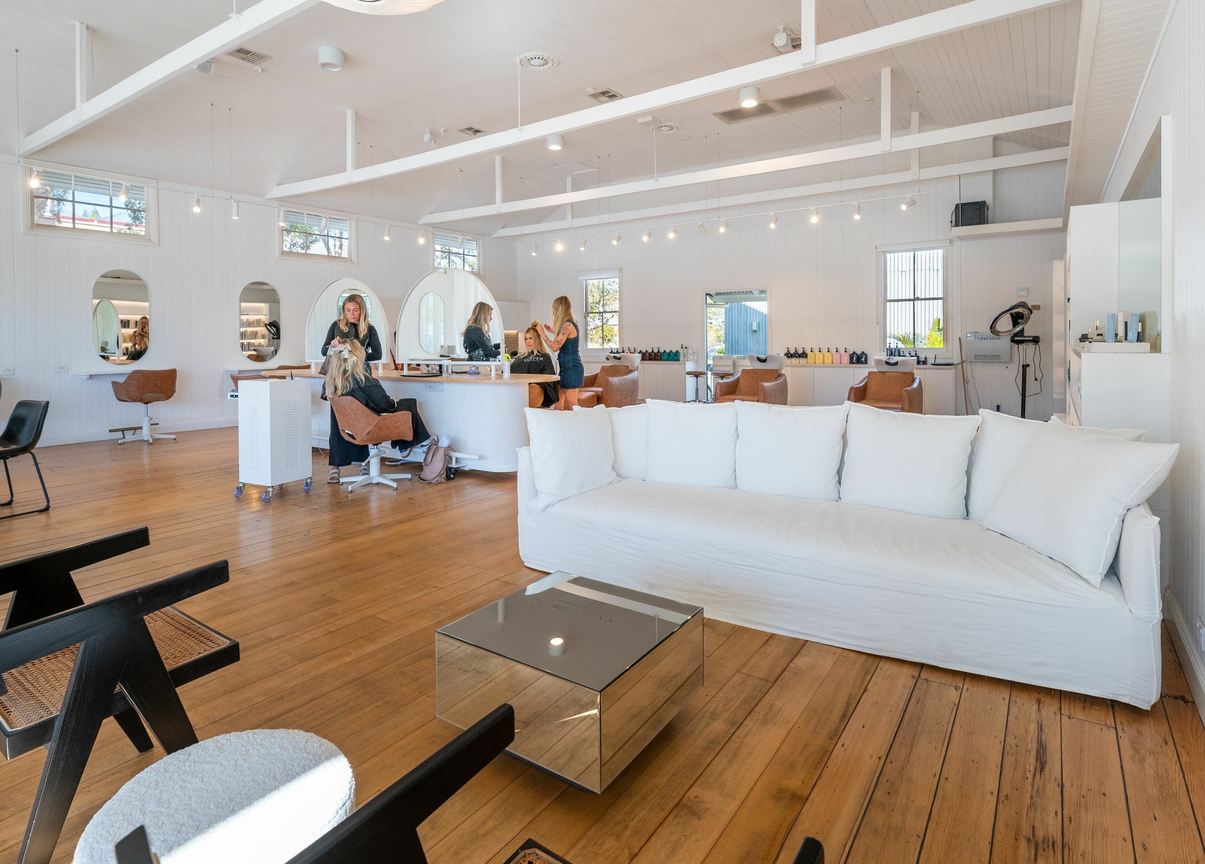 Chic interior of The Mane Society in Kelvin Grove, Queensland, AU, showcasing modern styling stations and plush seating.