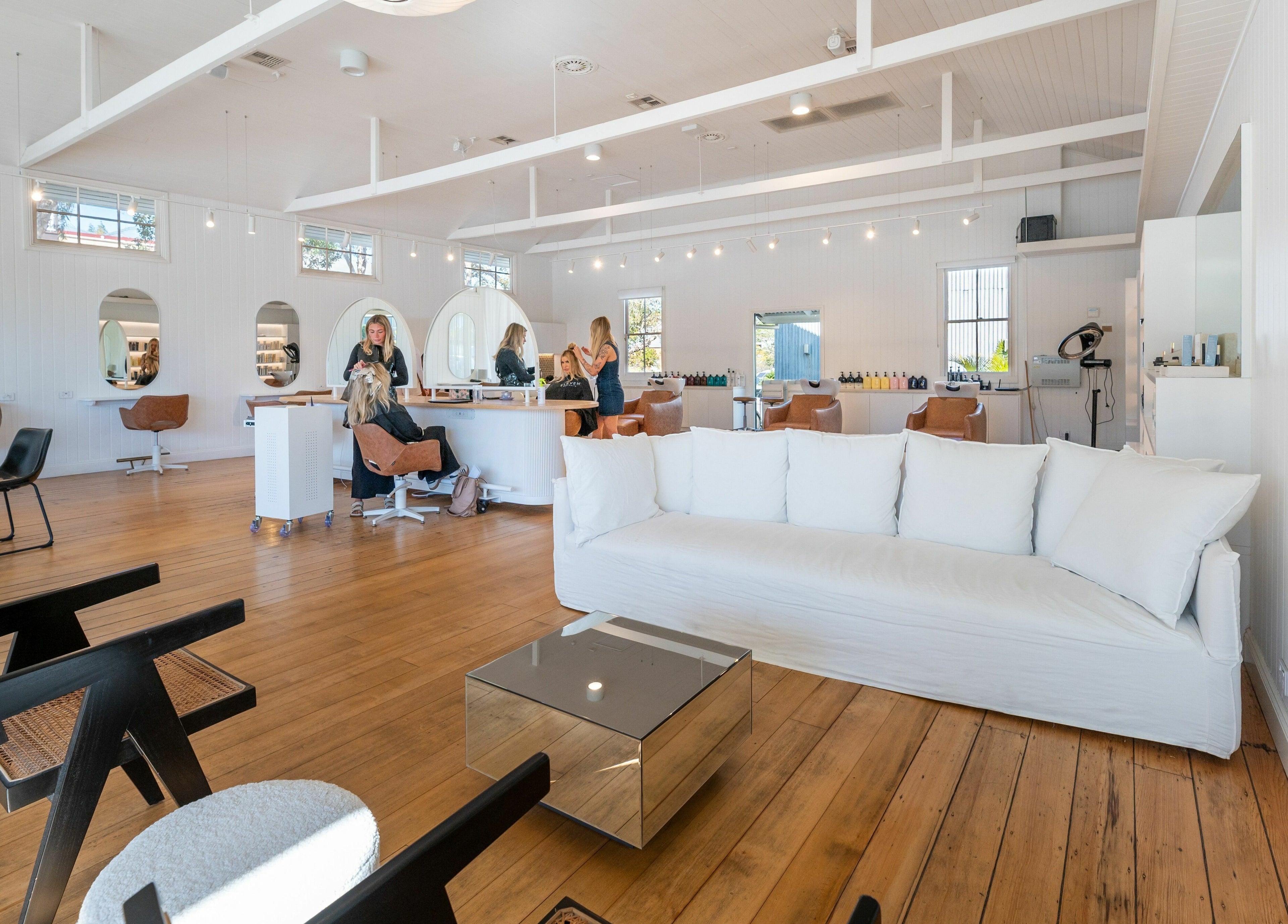 Chic interior of The Mane Society in Kelvin Grove, Queensland, AU, showcasing modern styling stations and plush seating.