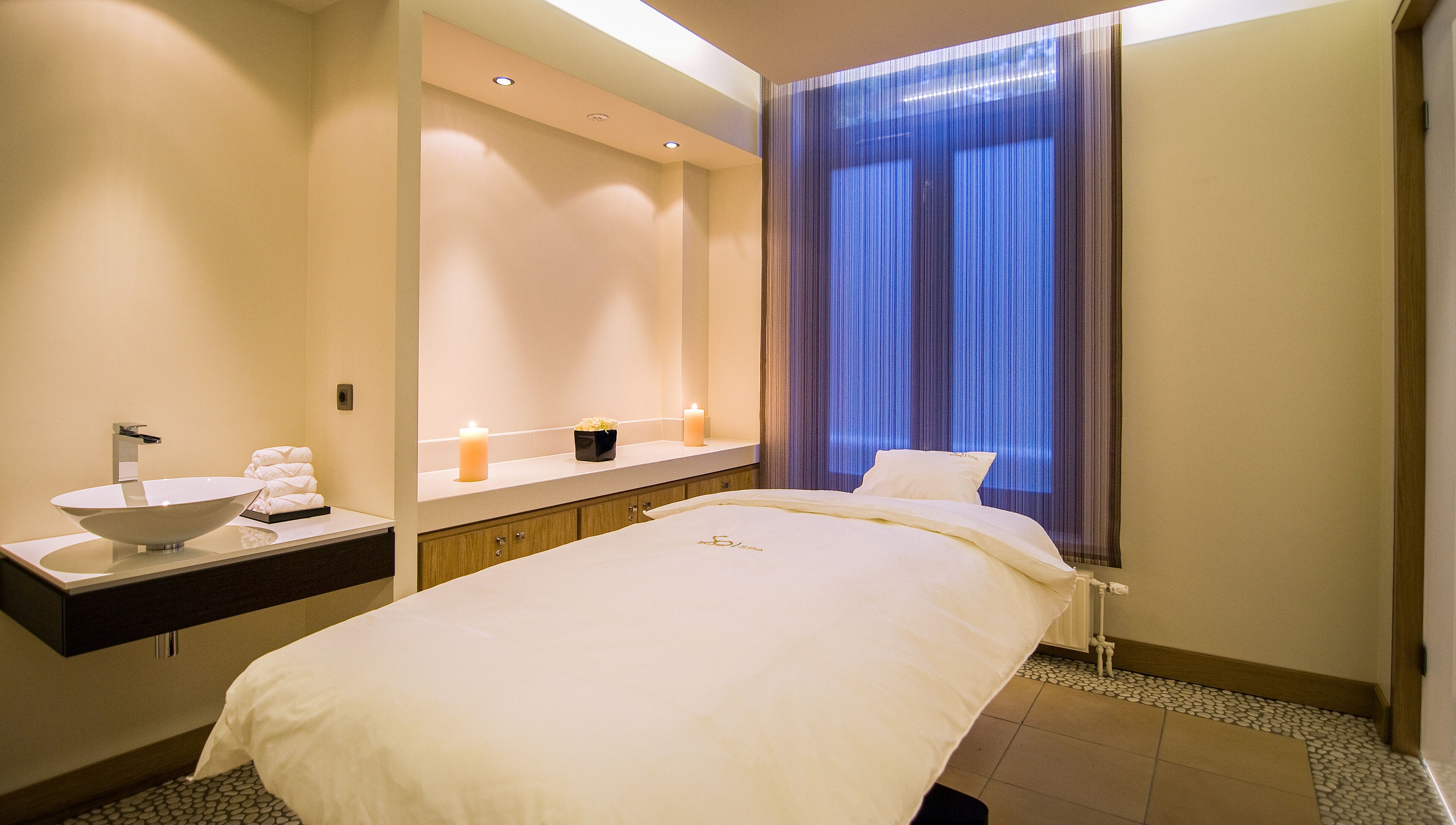 Peaceful spa room at Sofitel Legend The Grand Amsterdam, Noord-Holland, NL, with cozy massage bed and candles.