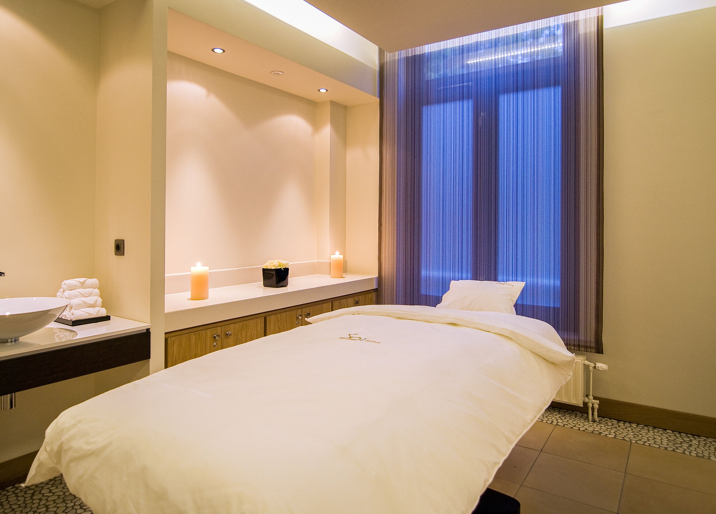 Peaceful spa room at Sofitel Legend The Grand Amsterdam, Noord-Holland, NL, with cozy massage bed and candles.