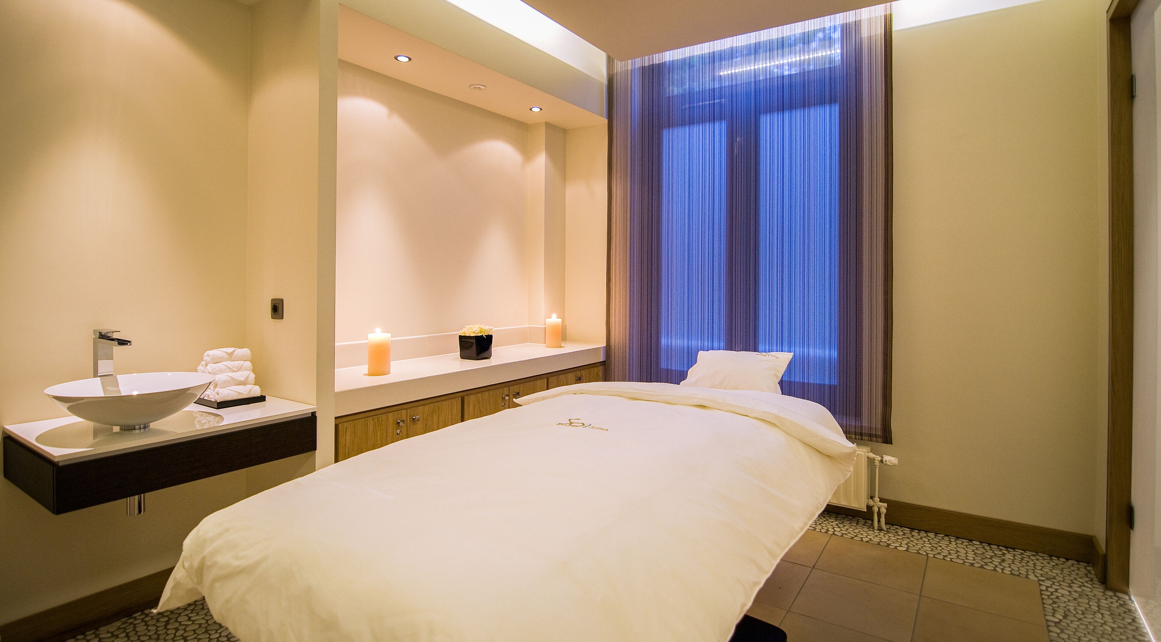 Peaceful spa room at Sofitel Legend The Grand Amsterdam, Noord-Holland, NL, with cozy massage bed and candles.