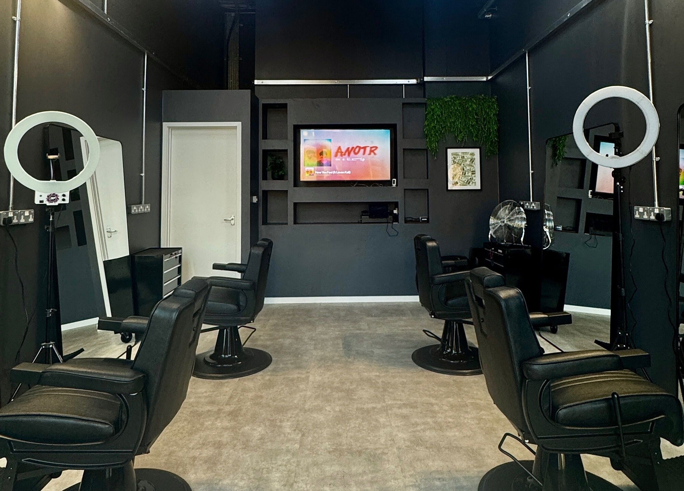 Chic interior of Sevens Barbershop in Exeter, England, GB showcasing modern black barber chairs and stylish decor.