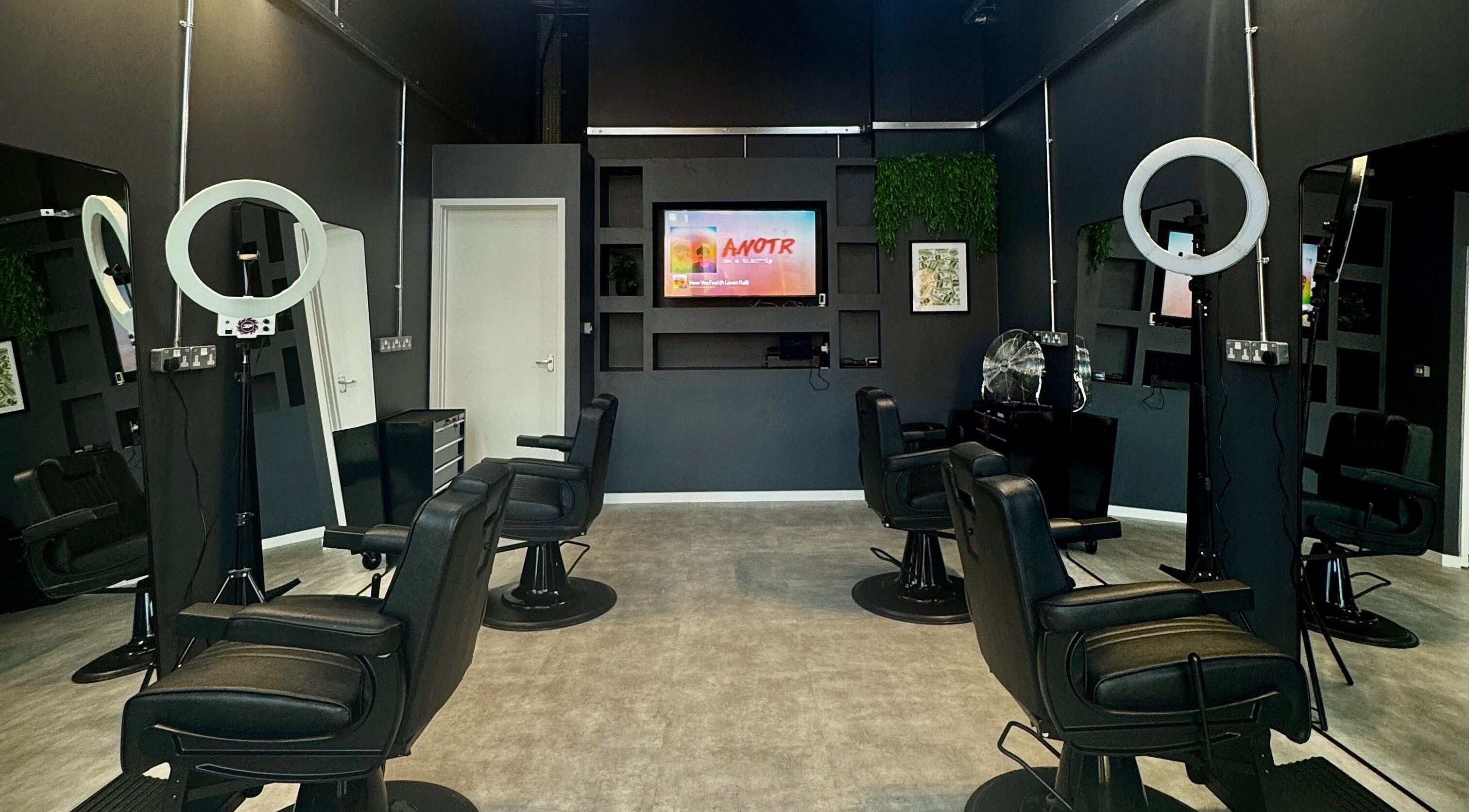 Chic interior of Sevens Barbershop in Exeter, England, GB showcasing modern black barber chairs and stylish decor.