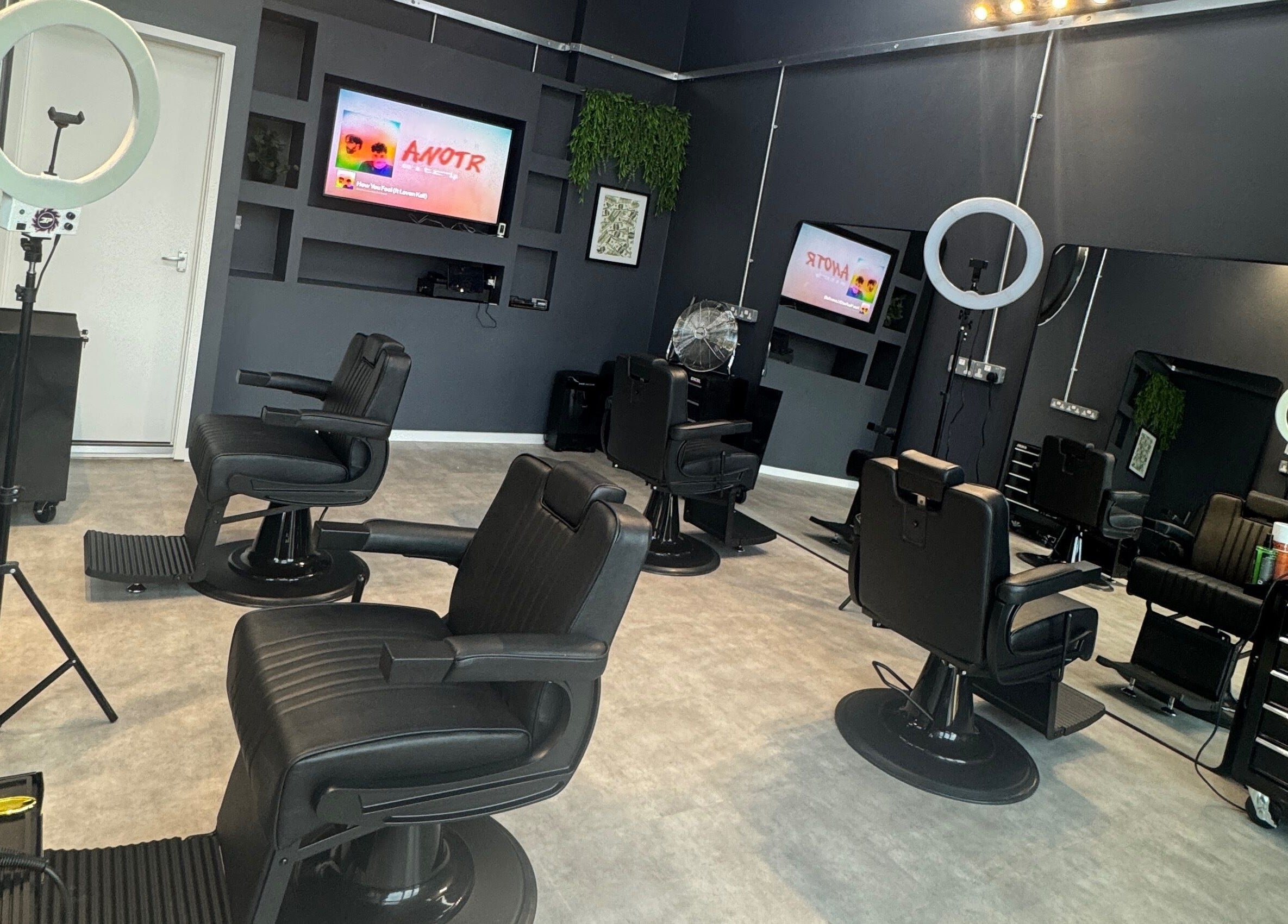 Modern interior of Sevens Barbershop, Exeter, England, GB, with sleek black barber chairs and stylish decor.