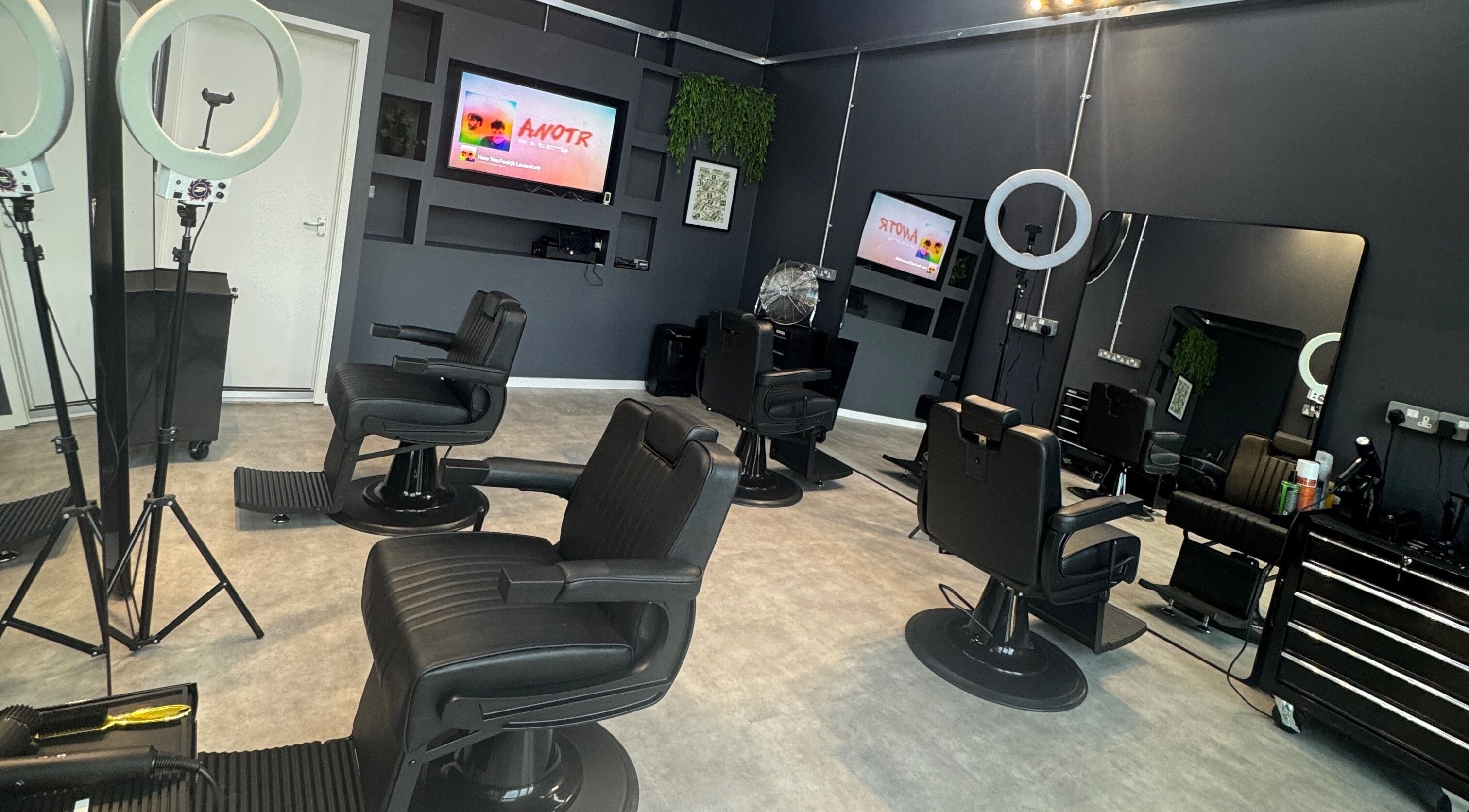 Modern interior of Sevens Barbershop, Exeter, England, GB, with sleek black barber chairs and stylish decor.