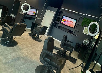 Sevens Barbershop interior with sleek chairs and modern decor, Exeter, England, GB.
