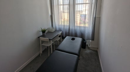 Serene massage room at Garry Christie Sports Massage, Glasgow, Scotland, GB featuring a comfortable black massage table.