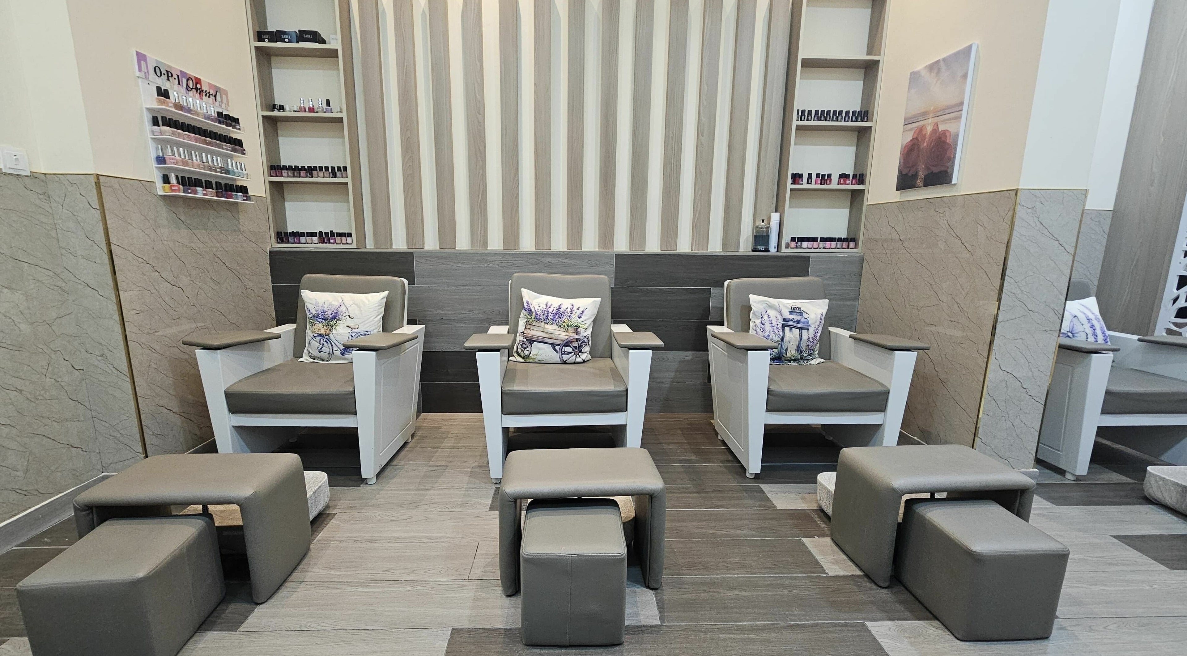 Elegant pedicure area at Malak Beauty Center in Sharjah, AE showcasing comfortable chairs and nail polish display.