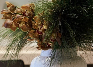 Elegant floral arrangement at Clipso Hair, Castlecrag, NSW, AU, featuring orchids and green foliage.