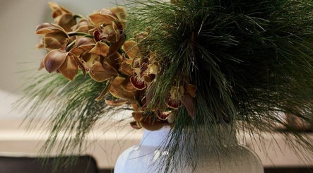 Elegant floral arrangement at Clipso Hair, Castlecrag, NSW, AU, featuring orchids and green foliage.