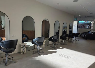 Elegant interior of Salon Lio in Crows Nest, New South Wales, AU, featuring stylish black chairs and mirrors.