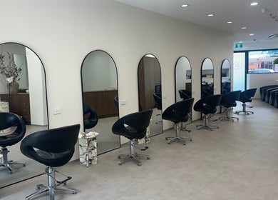 Modern salon setup at Salon Lio, Crows Nest, New South Wales, AU, featuring sleek black chairs and elegant mirrors.
