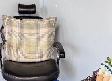 Elegant chair at K G Beauty - Located within Enliven, Edinburgh, Scotland, GB, with plaid cushion and products.