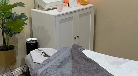 Cozy treatment room at K G Beauty, Edinburgh, Scotland, GB with bed, plants, and soft lighting.