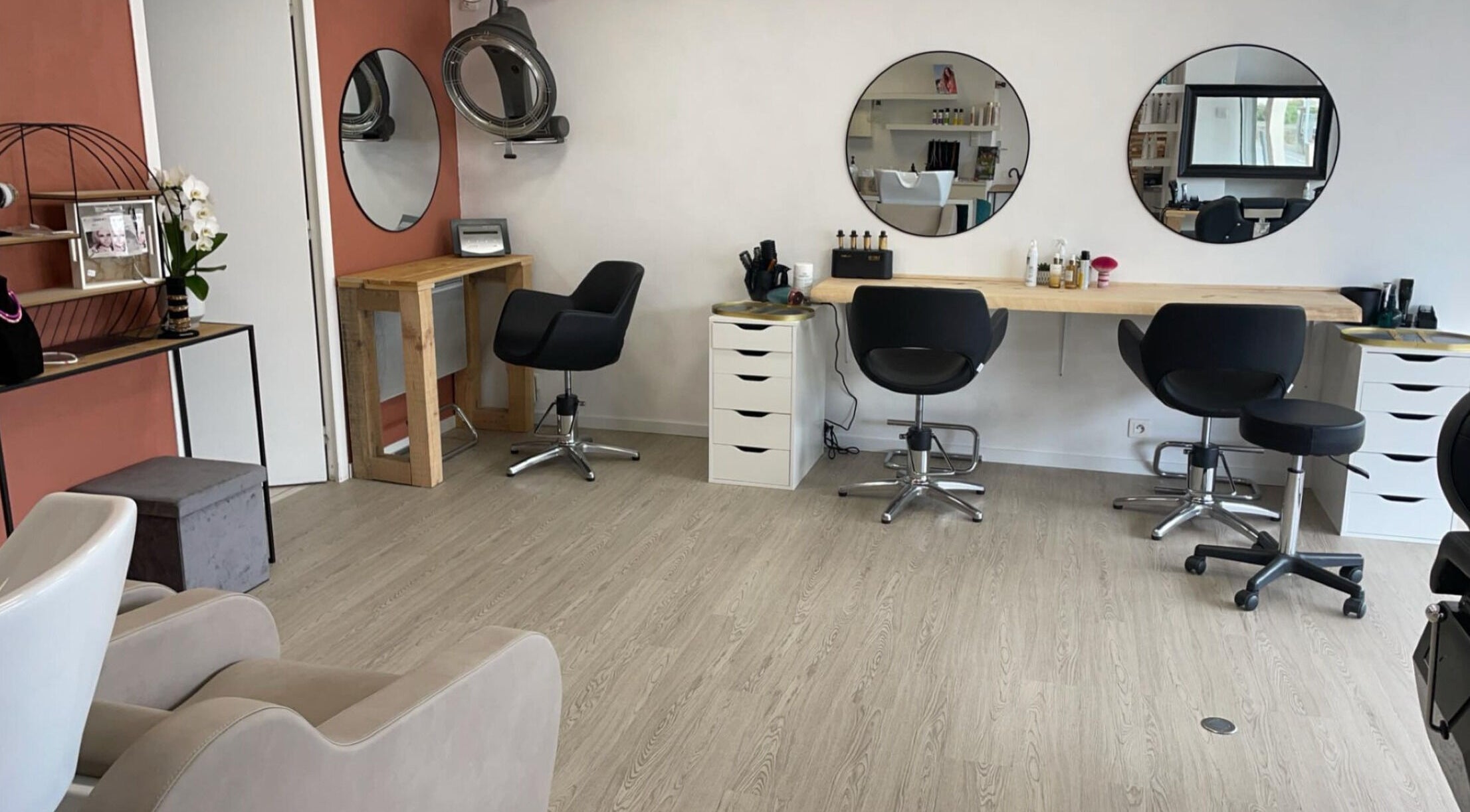 Intérieur élégant du salon Newstyl à Loireauxence, Pays De La Loire, FR, avec miroirs ronds et chaises modernes.