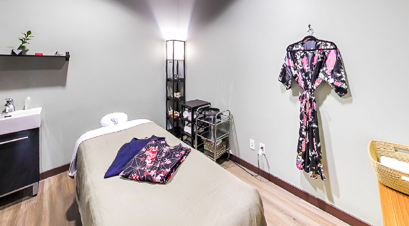Tranquil spa room at Sanatio Spa Japan in Vancouver, British Columbia, CA, featuring a massage table and elegant robe.