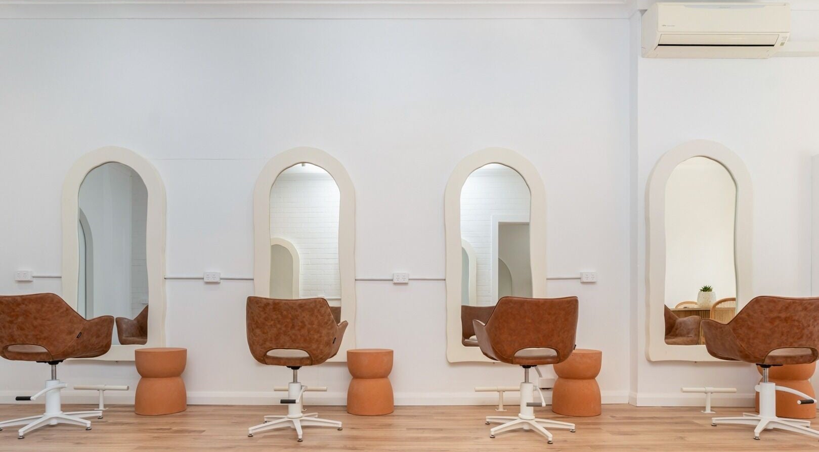 Elegant salon setup at The Aura Colab, Loftus, New South Wales, AU featuring stylish mirrors and chairs.