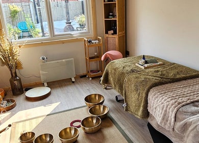 Tranquil therapy room at Calm by Nature Reflexology in Bromborough, England, GB, with singing bowls and soft lighting.
